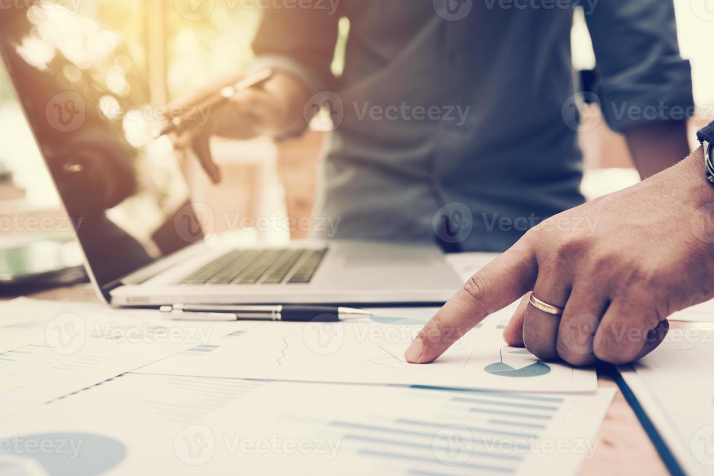 Co-working space office with group start-up analysis to data paper chart on desk. photo