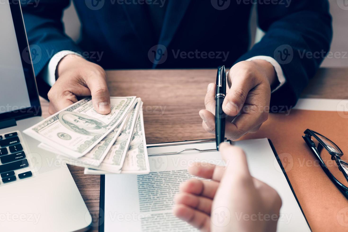 Partner has made a fraud in the contract of sale and being handed a cash and pen to the businessman signing the contract corruption bribery concept. photo