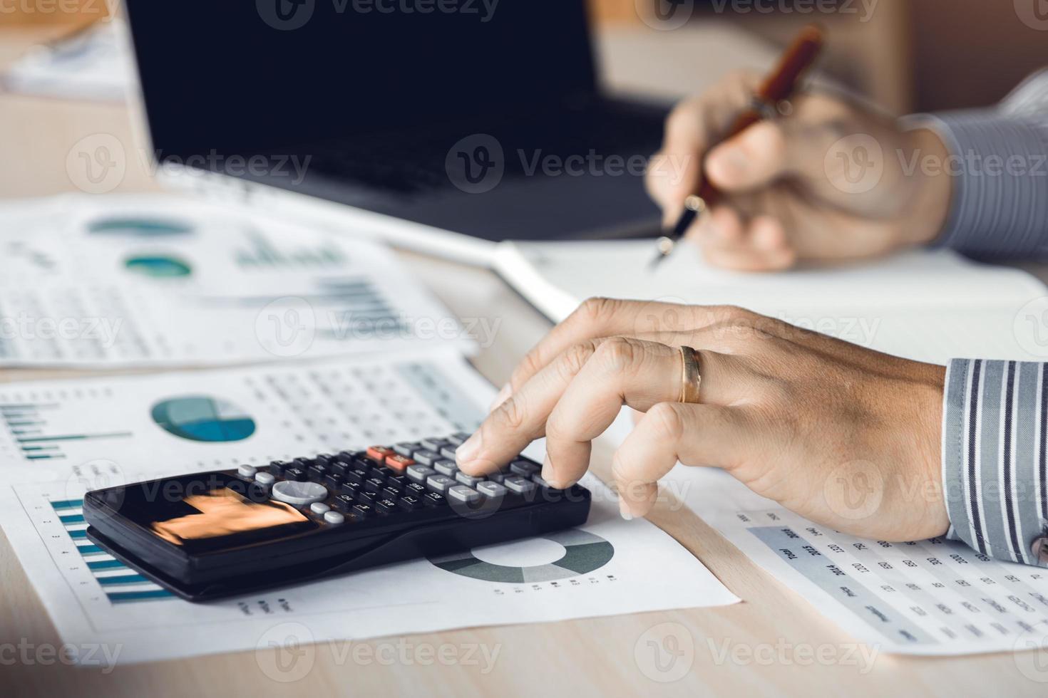 Businessman accountant pressing calculator and making calculation at