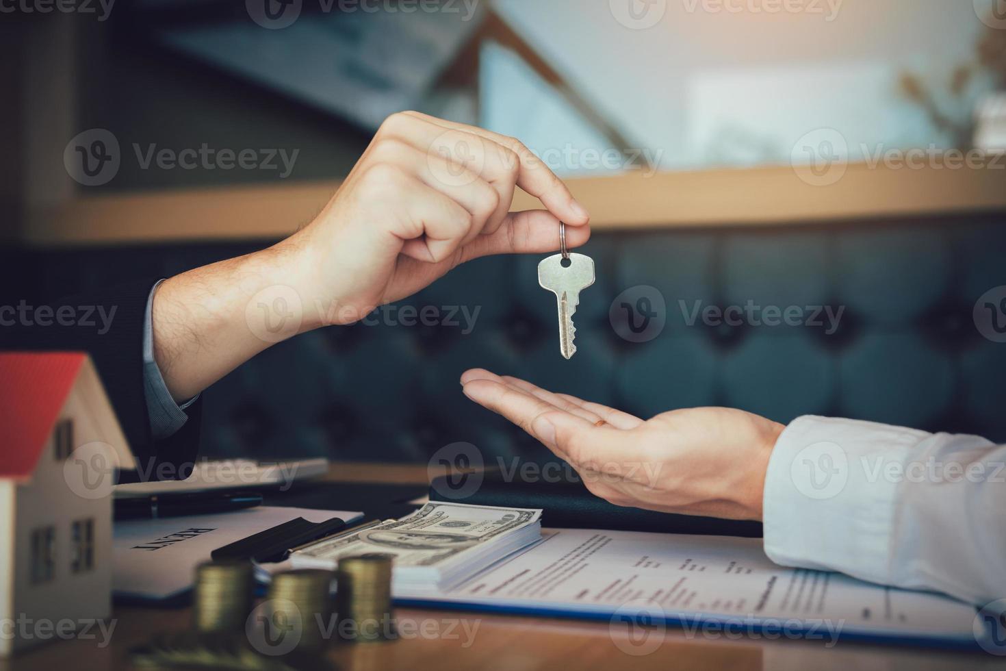 Home agents are handing out keys to home buyers who are signing contracts at the office. photo
