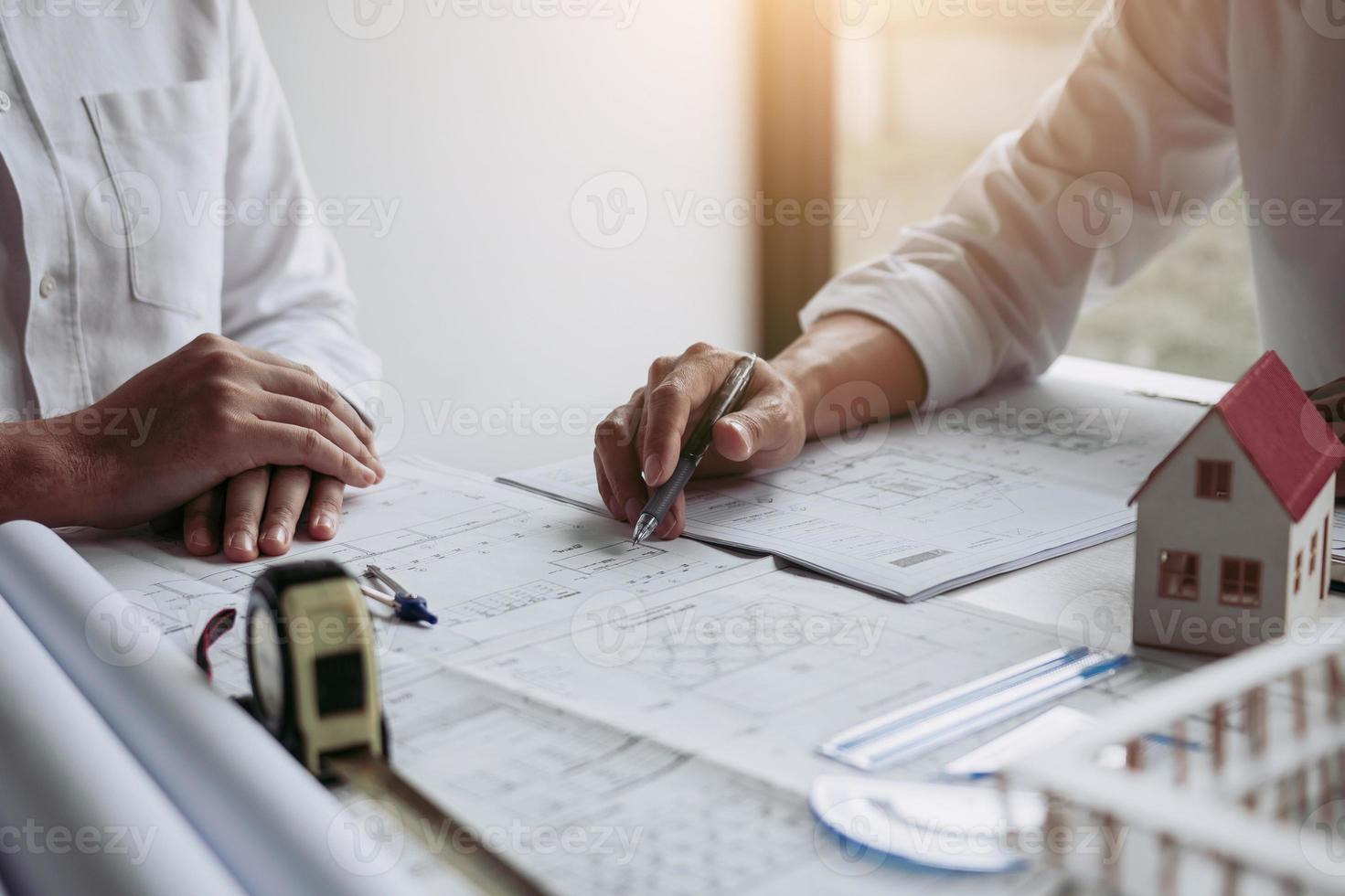 The partnership engineering man or co-workers working on a project and discussing together with looking at blueprint paperwork. photo
