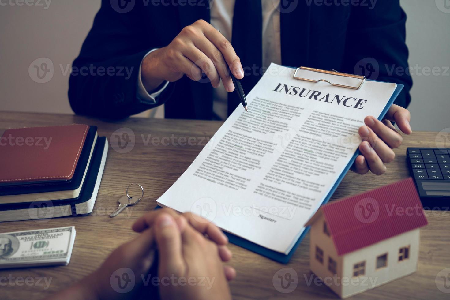 Agents are using pens pointing to insurance contracts and are being explained to customers at the office. photo