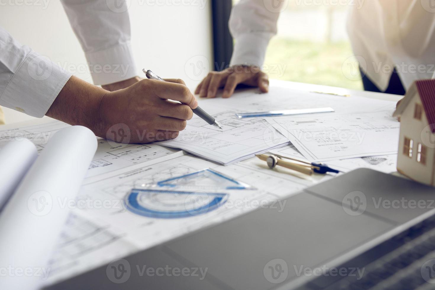 Engineering man showing blueprint detail for people buying house. photo