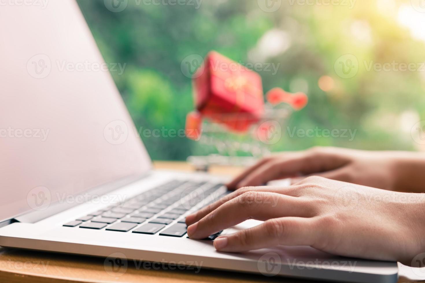 Finger of woman hands typing laptop keyboard with shopping online concept. photo