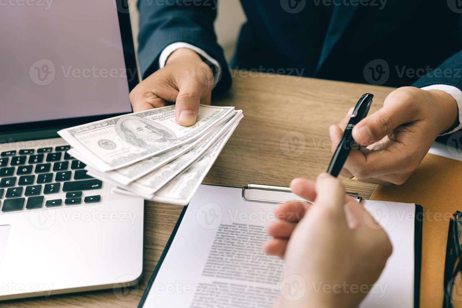Partner has made a fraud in the contract of sale and being handed a cash and pen to the businessman signing the contract corruption bribery concept. photo