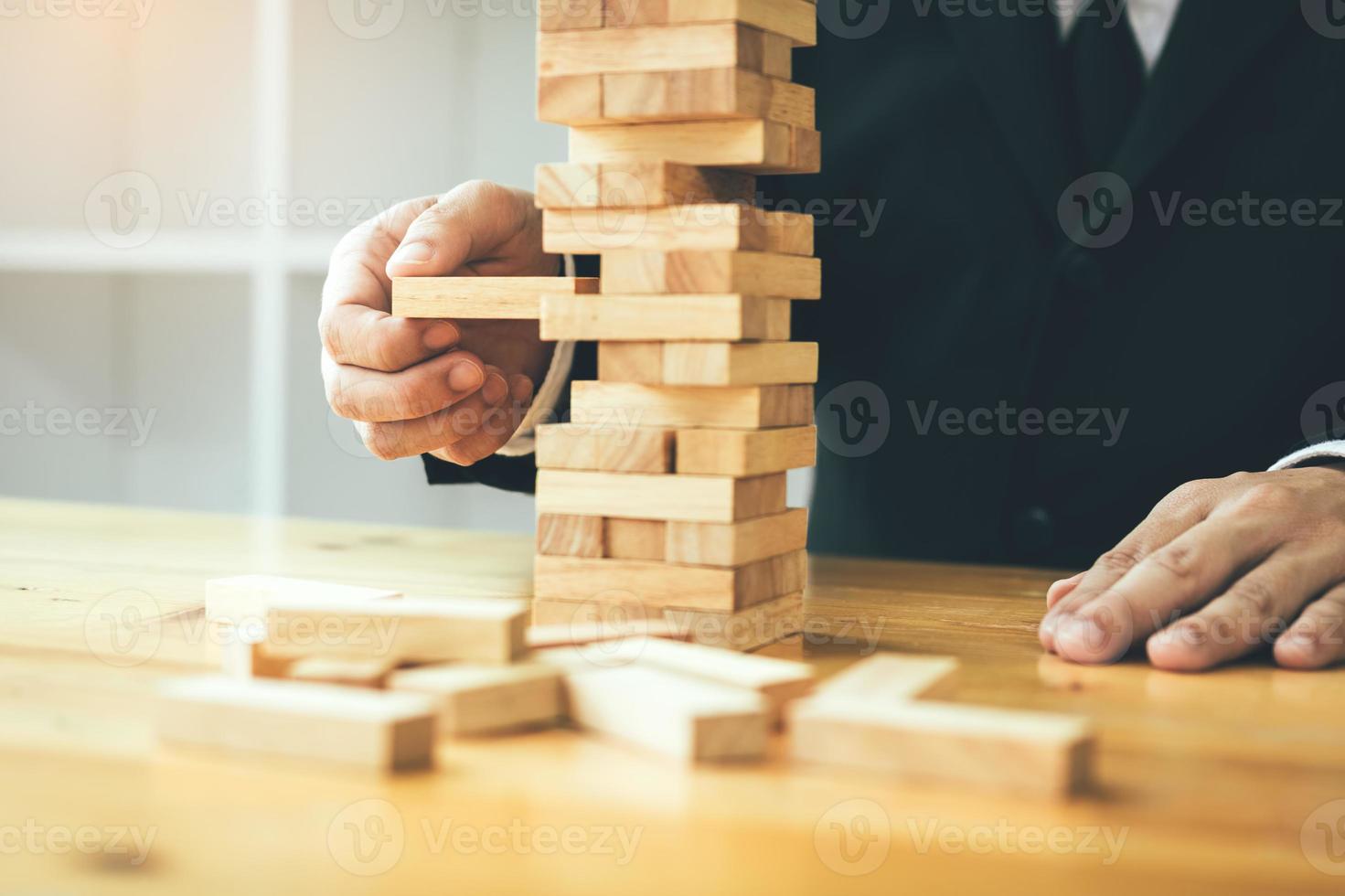 Strategic thinking and risk by business people pulls wooden blocks from the group. photo