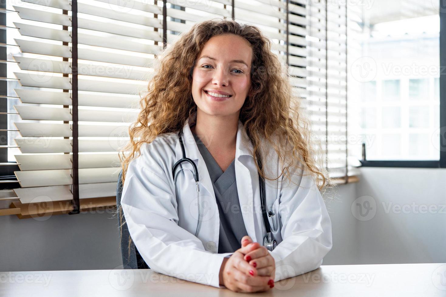 feliz sonriente doctora caucásica mirando la cámara mientras se reúne en línea con el paciente, los conceptos de servicio de videollamadas de consulta médica domiciliaria foto