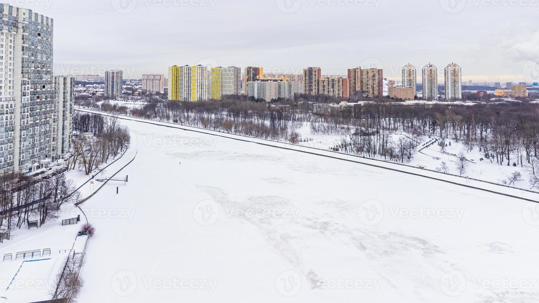 From the height there is a view of the icy river and the city embankment in winter photo