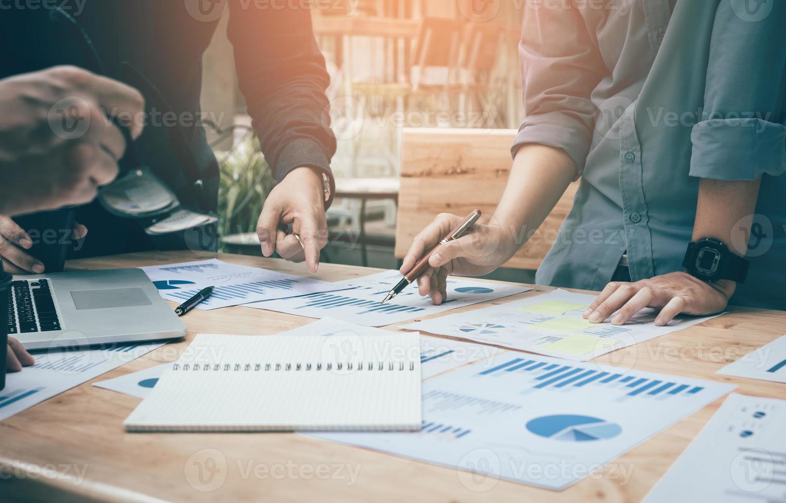 Co-working space office with group start-up analysis to data paper chart on desk. photo