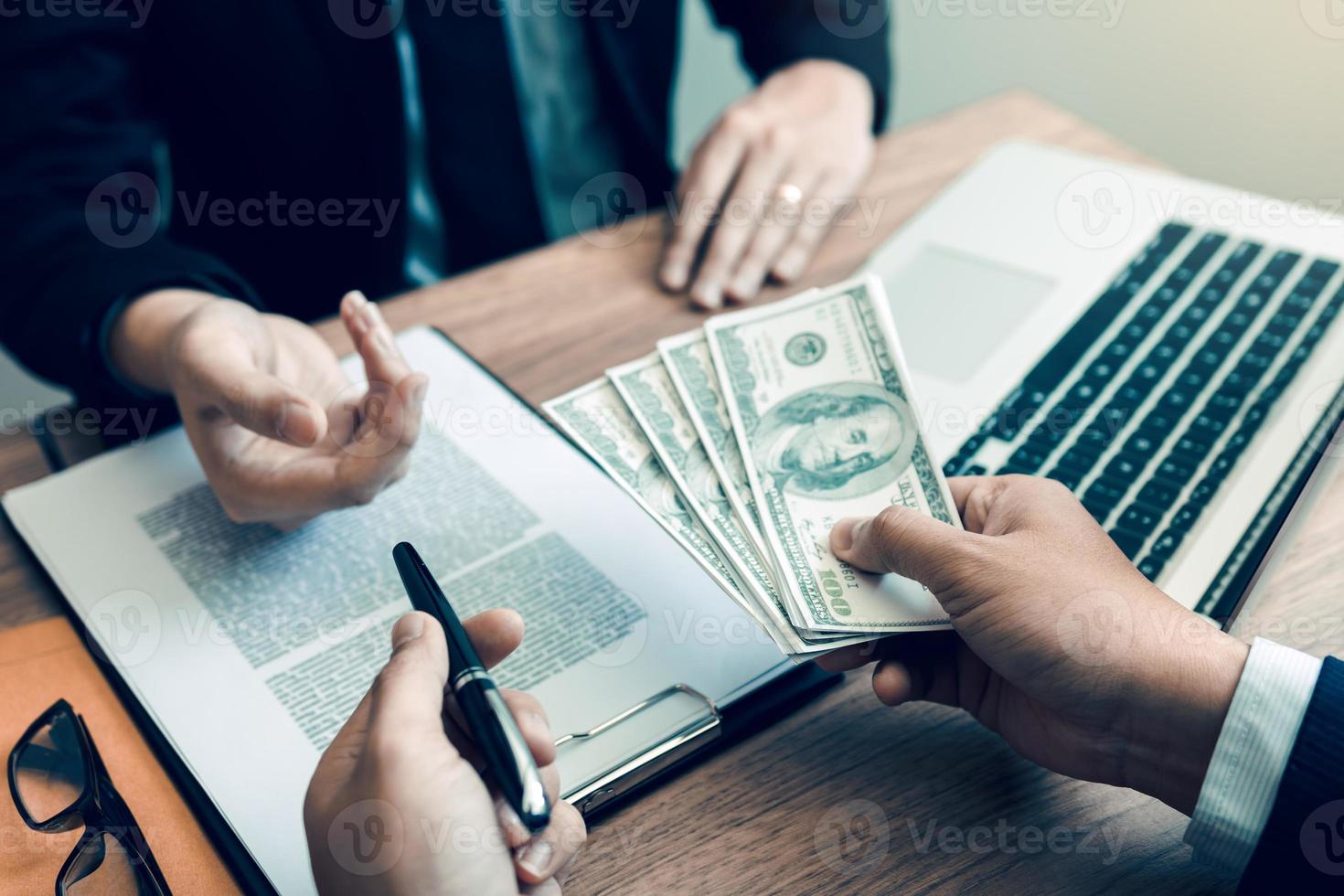 Partner has made a fraud in the contract of sale and being handed a cash and pen to the businessman signing the contract corruption bribery concept. photo