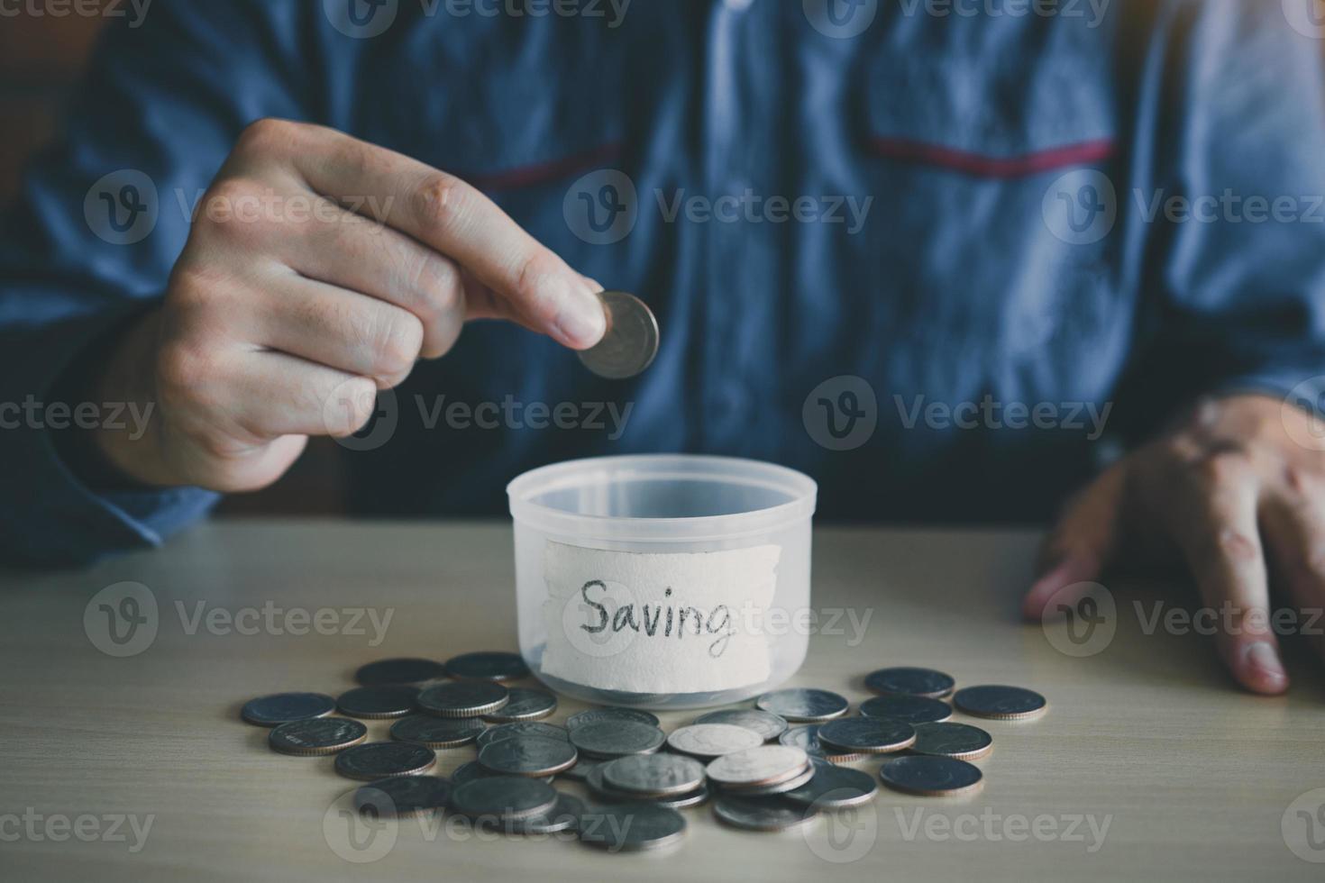 Men are holding coins dropping to the money box with the concept of saving. photo