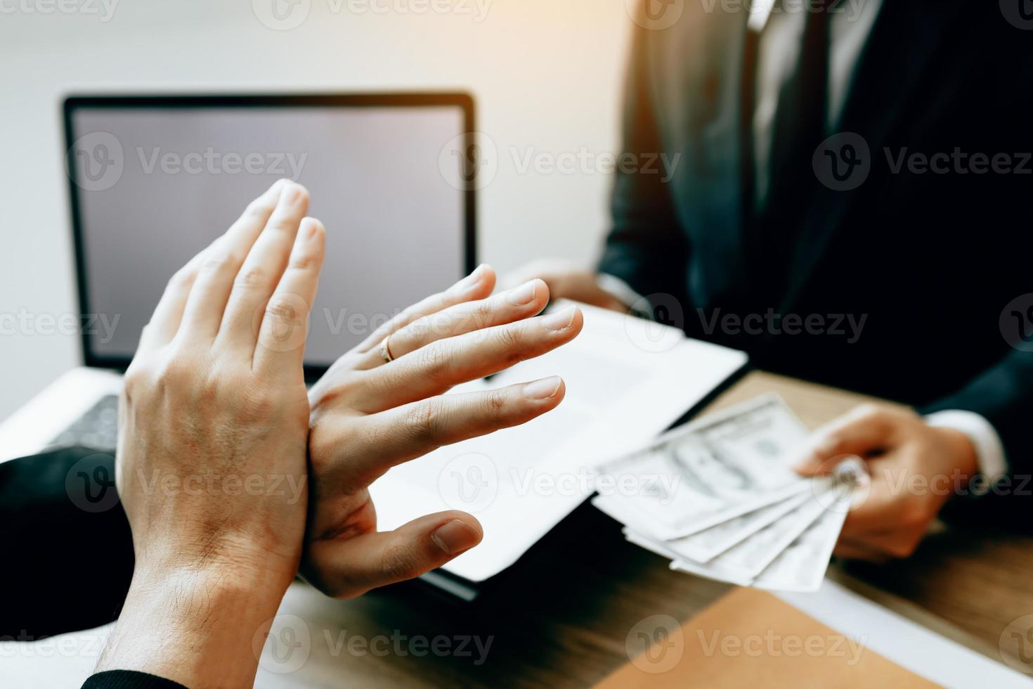 Businessperson refusing bribe given money by partner with anti bribery corruption concept. photo