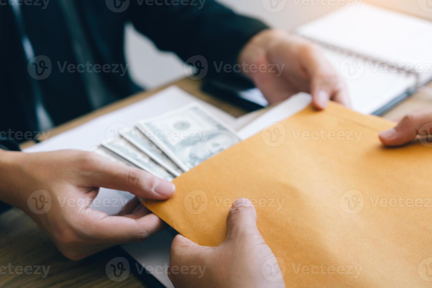 Two investors are having business secrets with cash being placed in the document envelope to bribe employees. photo