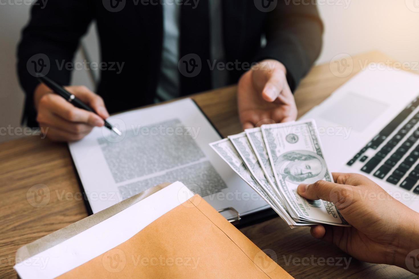 los empresarios están recibiendo dinero que es un soborno de sus socios con los cuales ambos son corruptos en la sala de la empresa. foto