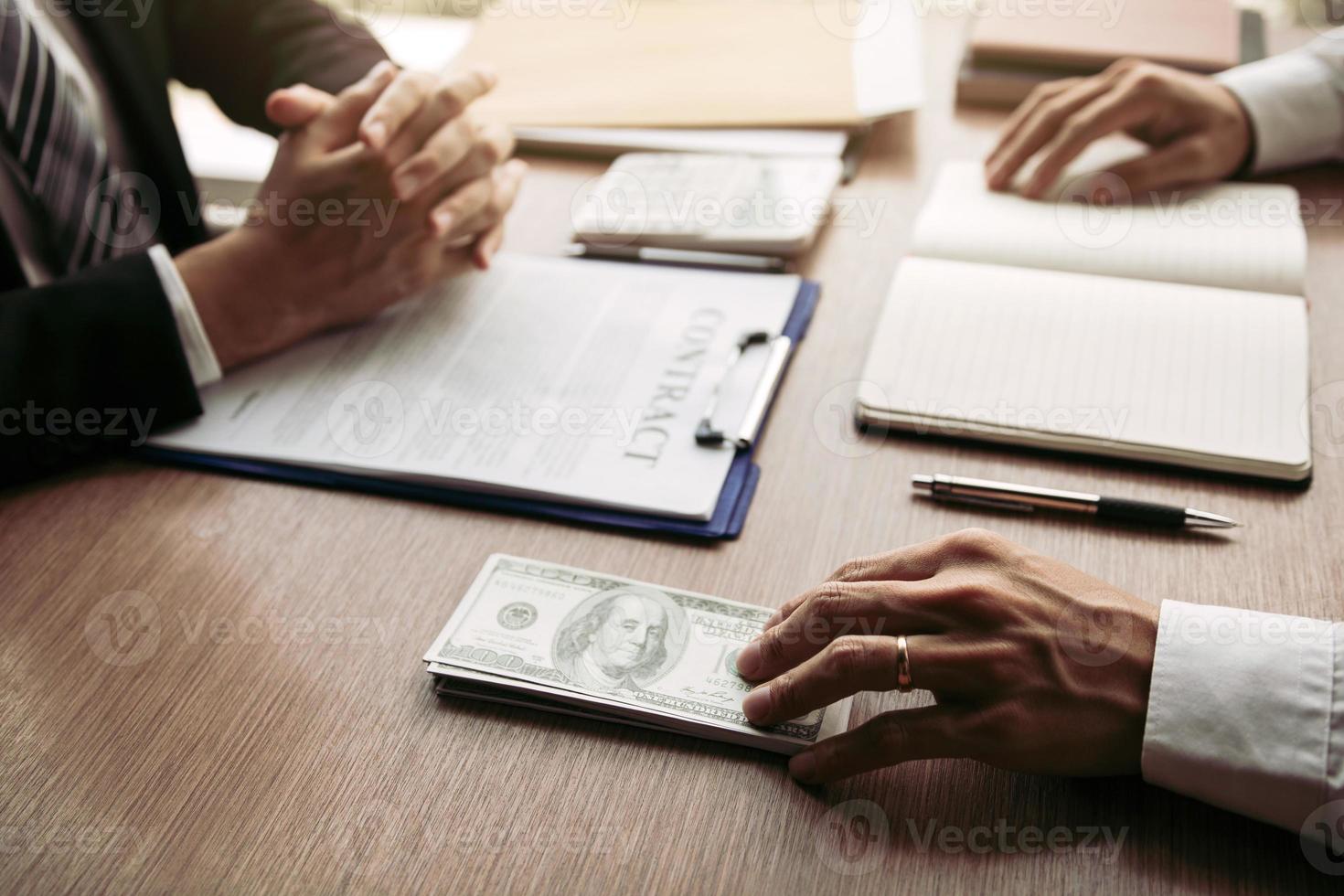 el socio ha cometido un fraude en el contrato de venta y se le entregó un efectivo y un bolígrafo al empresario que firma el concepto de soborno de corrupción del contrato. foto