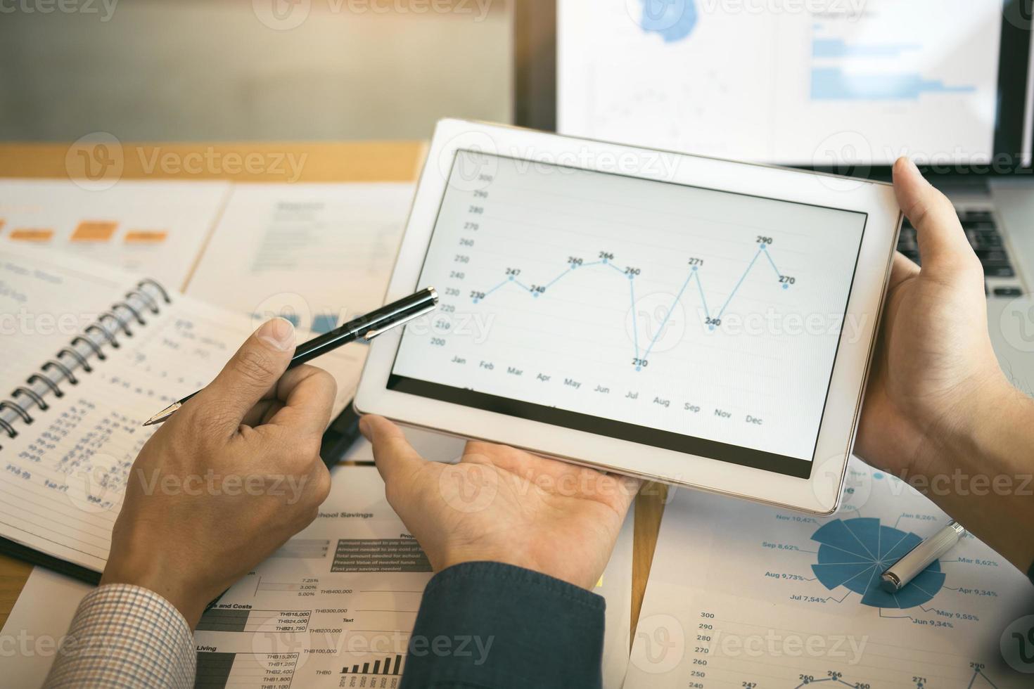 Business partnership coworkers analysis cost work progress and using a tablet to graph company financial budget report and planning for future in office room. photo