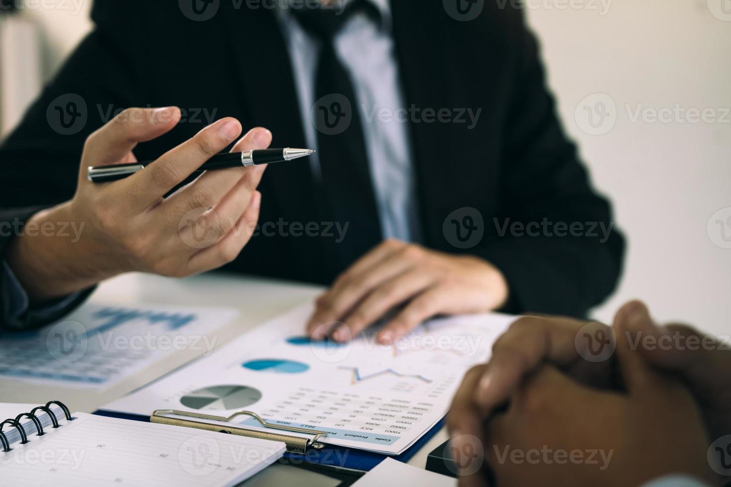 Two business partnership coworkers analysis cost work progress and gesturing with discussing a financial planning graph and company financial during a budget meeting in office room. photo