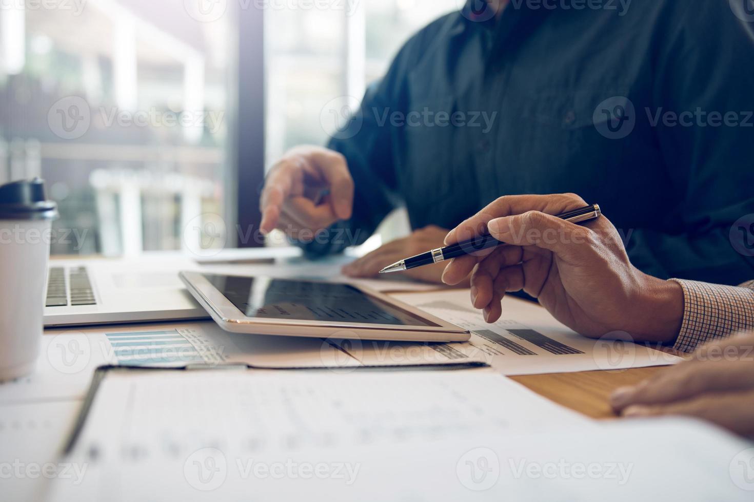 Business partnership coworkers analysis cost work progress and using a tablet to graph company financial budget report and planning for future in office room. photo
