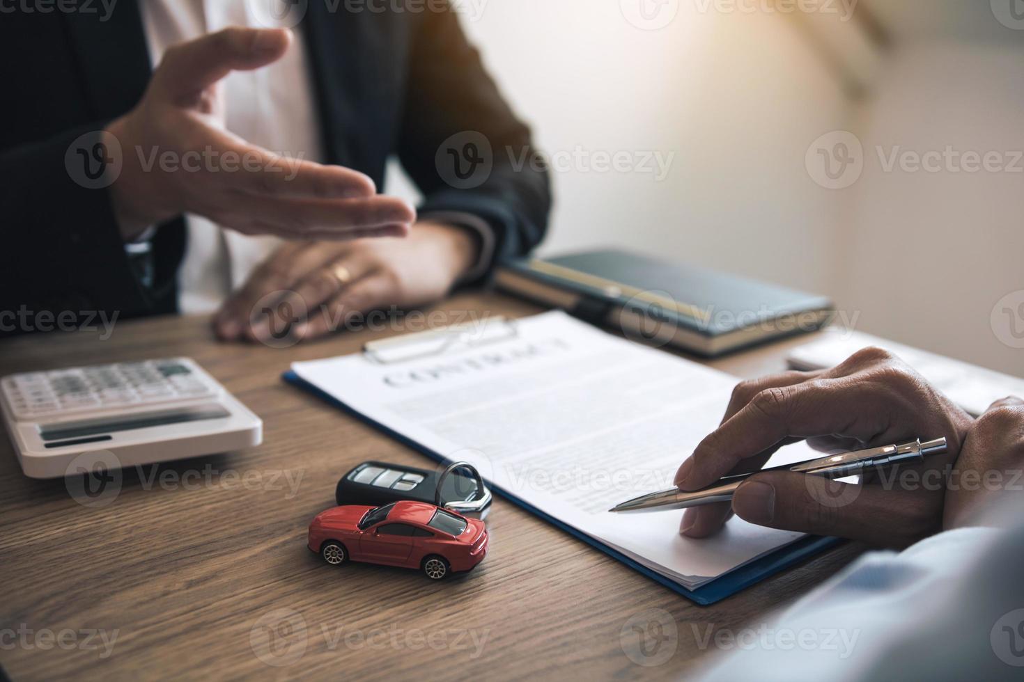 el vendedor de autos del agente está explicando sobre el nuevo contrato de compra de autos y el acuerdo con el comprador de autos. foto