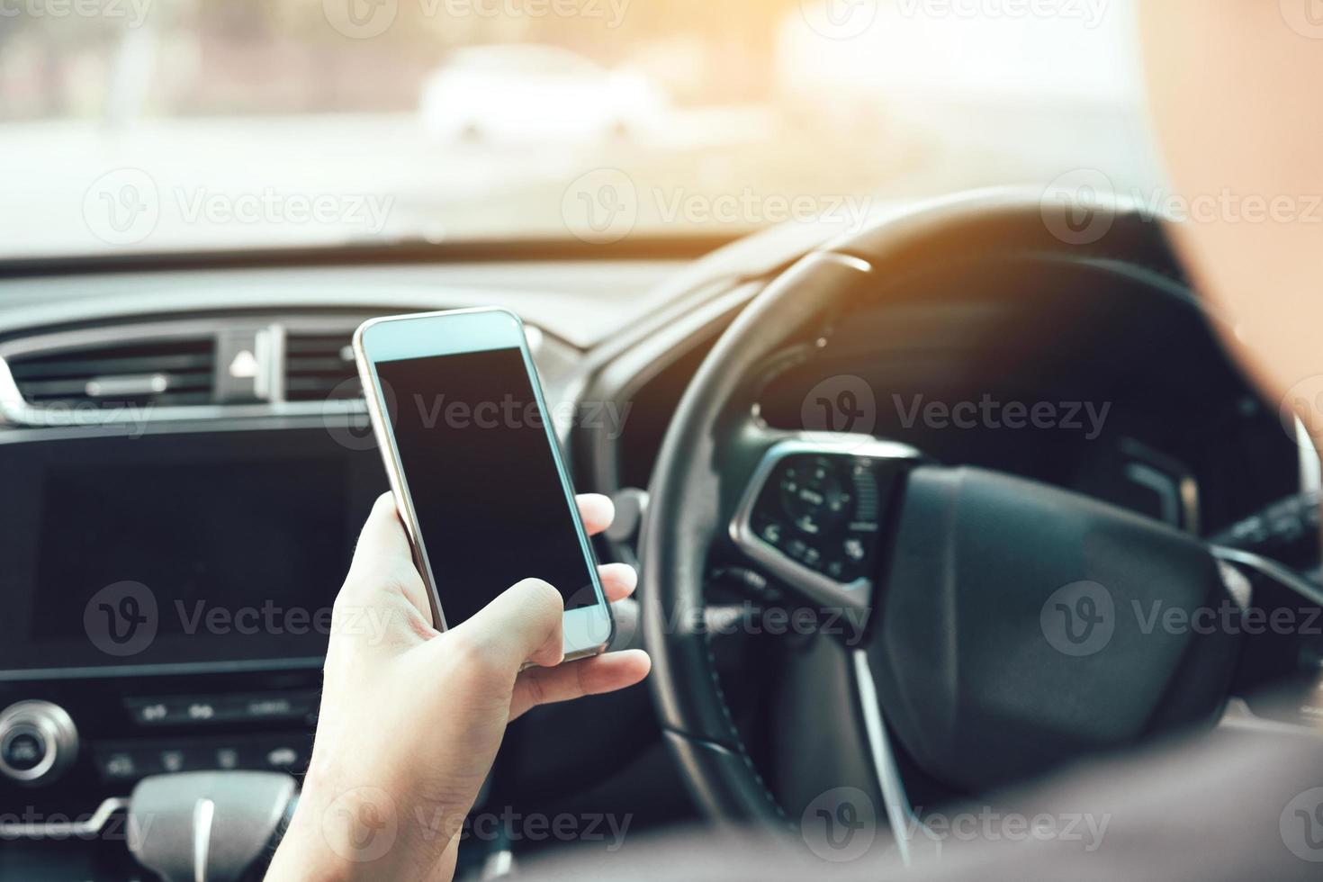 The man hand is using the phone while driving. photo