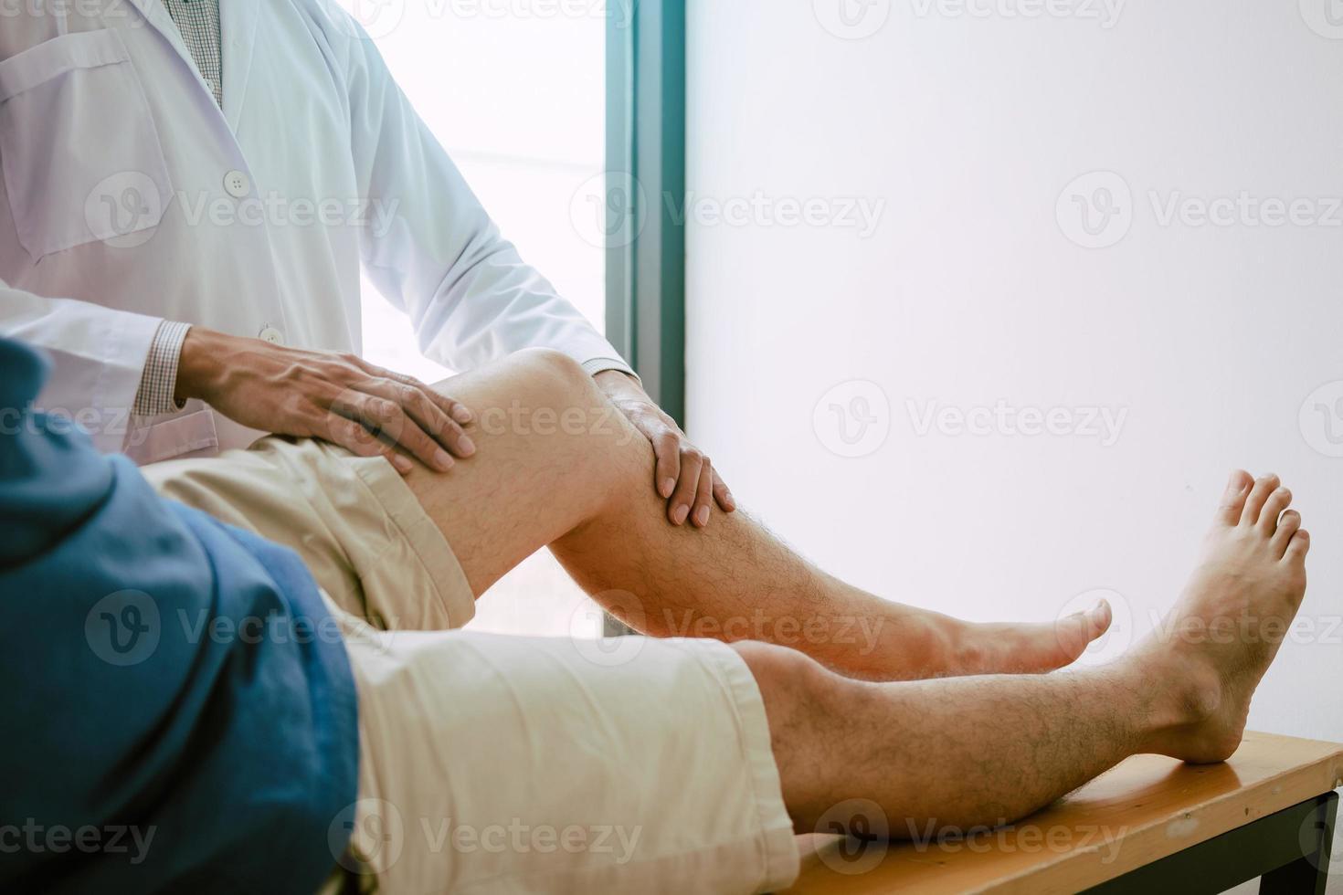 los fisioterapeutas están usando el mango en la rodilla del paciente para comprobar si hay dolor. foto