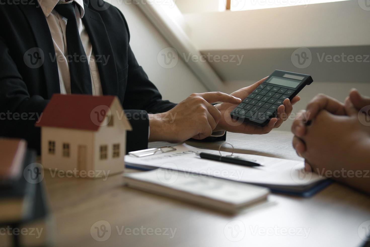 Agents are calculating the loan payment rate or the amount of insurance premiums for customers coming to contact the purchase of a new home at the office. photo