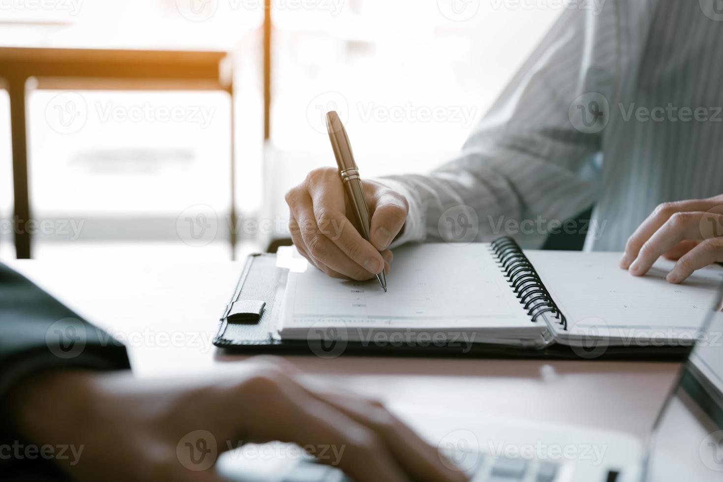 Consultant making note summary report with manager using laptop on desk in office room. photo