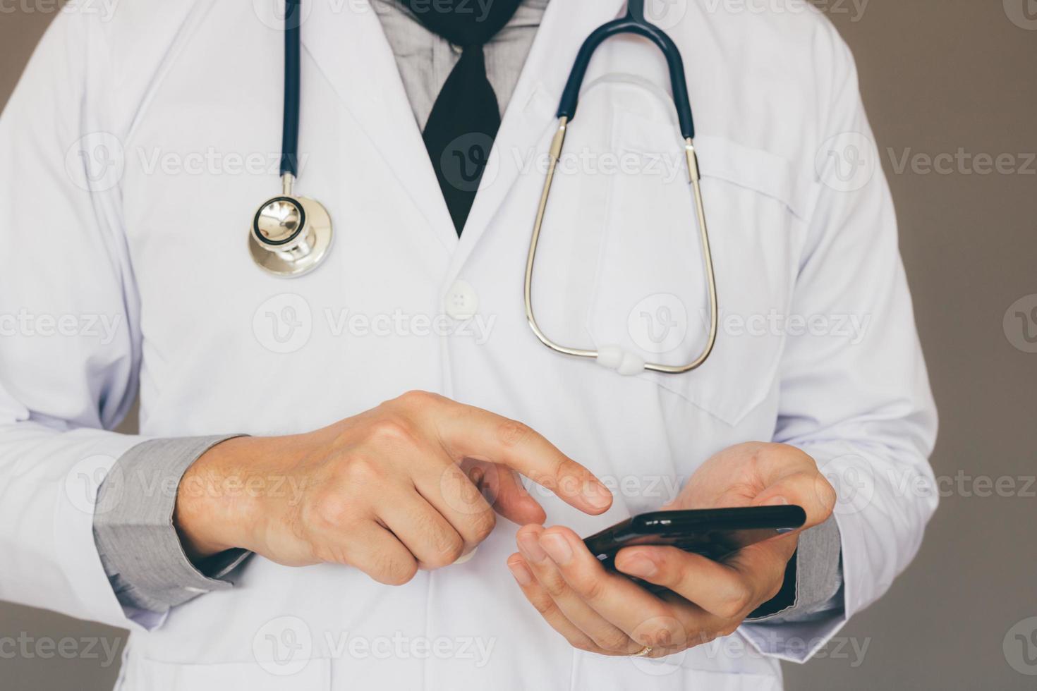 Doctor using smartphone and typing to screen. photo