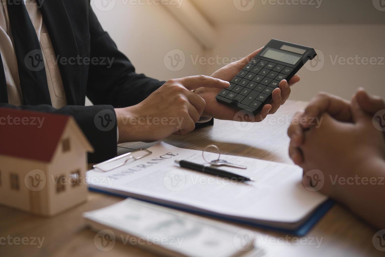 Agents are calculating the loan payment rate or the amount of insurance premiums for customers coming to contact the purchase of a new home at the office. photo