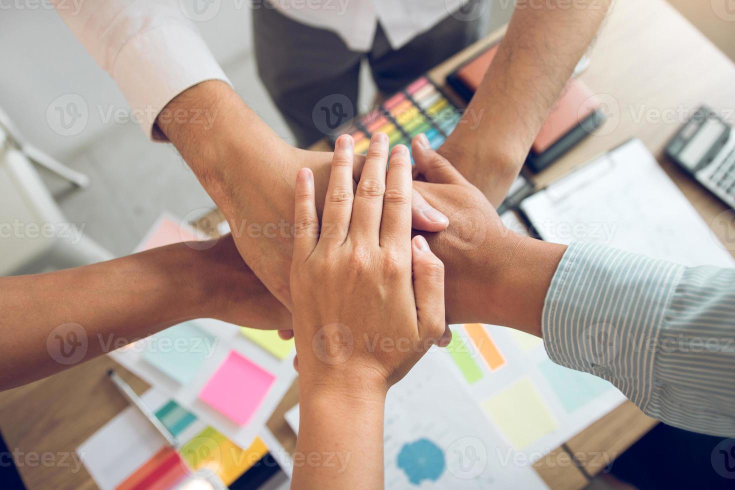 Close up of group of business people joining their hands together in unity. photo