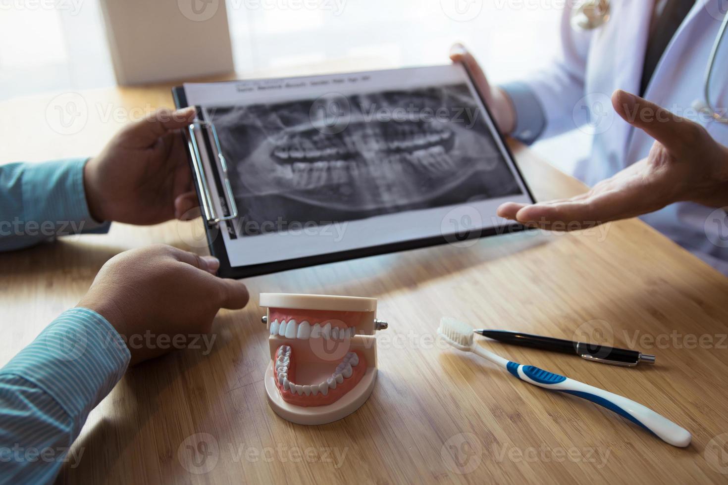 Dentists are discussing dental problems at report x-ray image for patients. photo