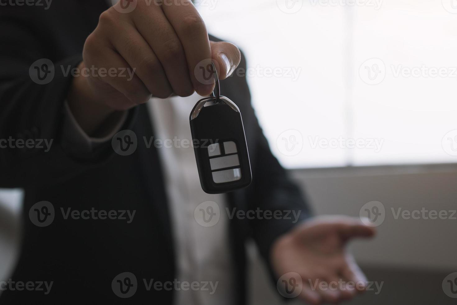 Car sales agent are car keys with the idea of buying a new car. photo