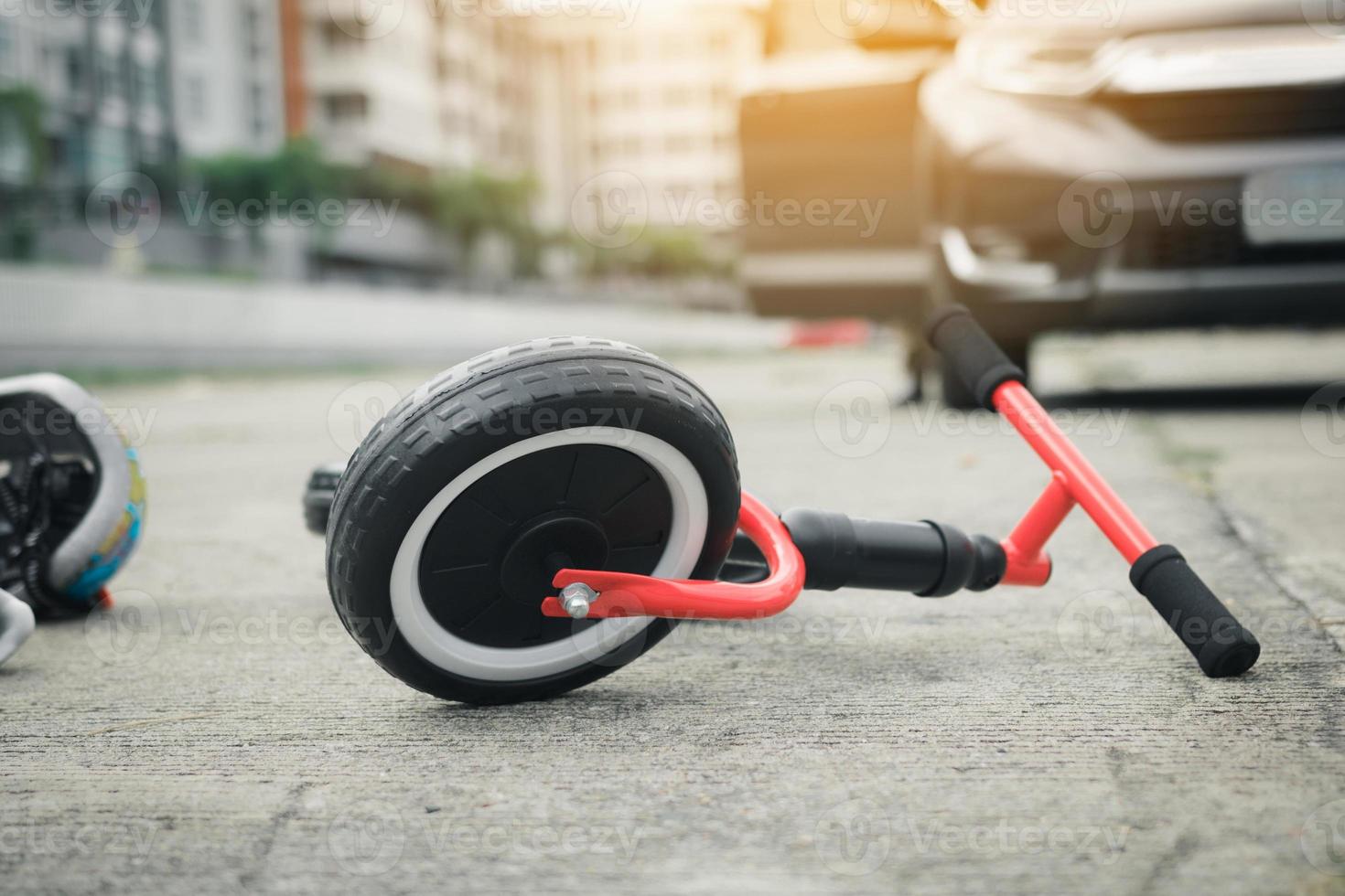 The child bike is on the ground with a car crash. photo