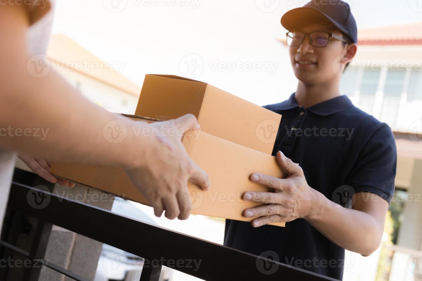 cerca de las manos el personal de carga está entregando cajas de cartón con paquetes dentro de la mano del destinatario. foto