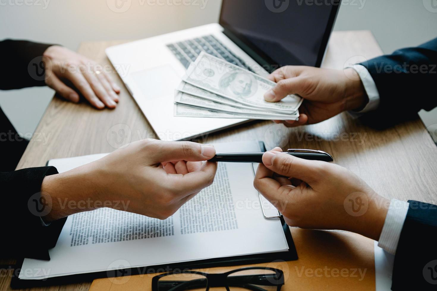 Partner has made a fraud in the contract of sale and being handed a cash and pen to the businessman signing the contract corruption bribery concept. photo