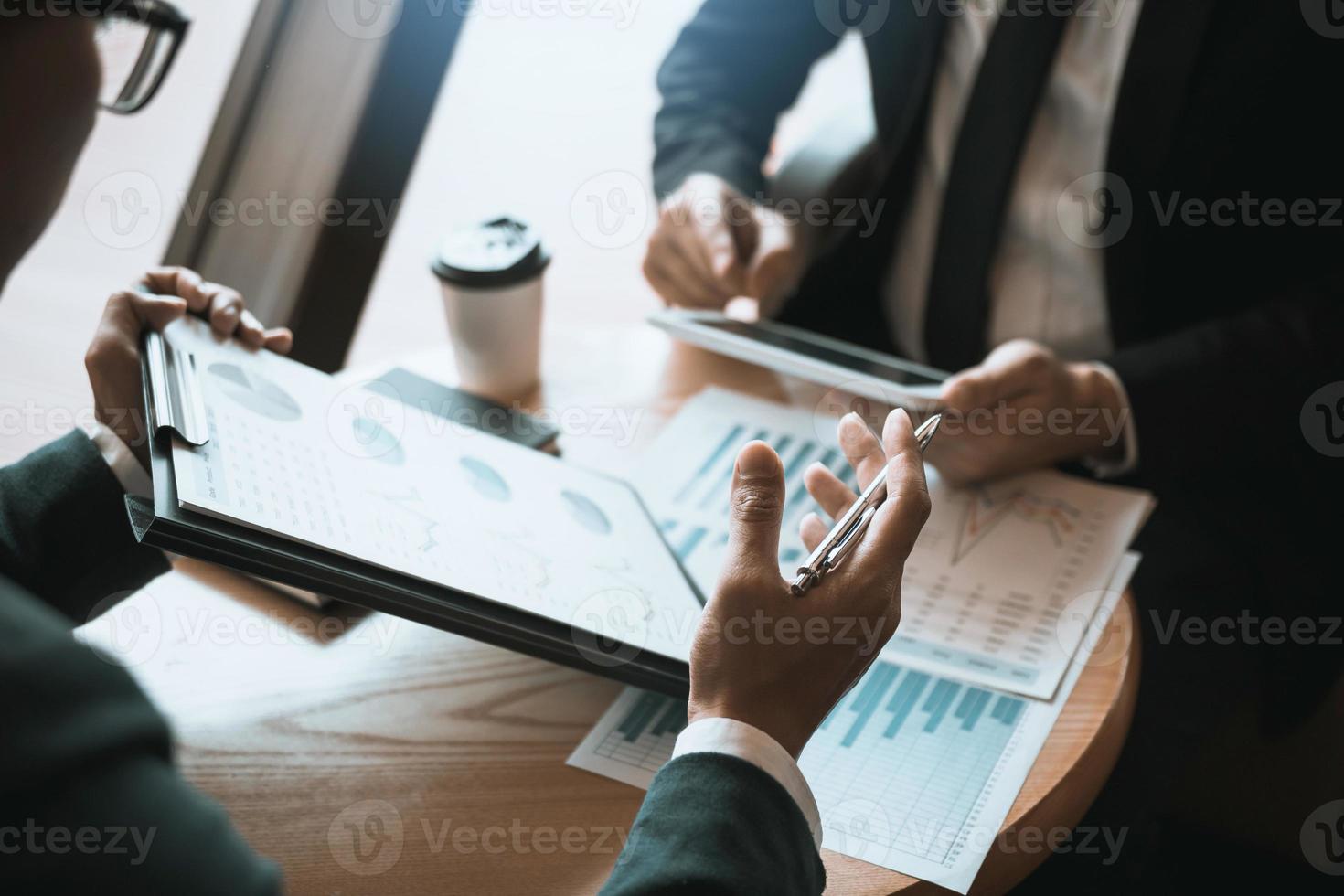 Business partnership coworkers using a tablet to chart company financial statements report and profits work progress and planning in office room. photo