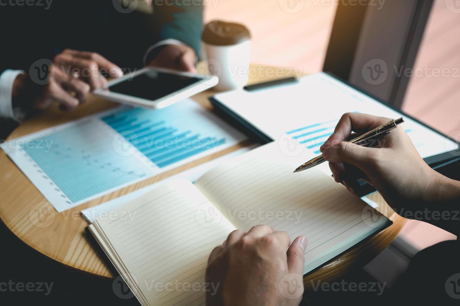 Business partnership coworkers using a tablet to chart company financial statements report and profits work progress and planning in office room. photo