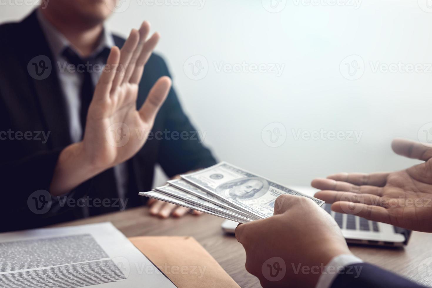 Businessperson refusing bribe given money by partner with anti bribery corruption concept. photo