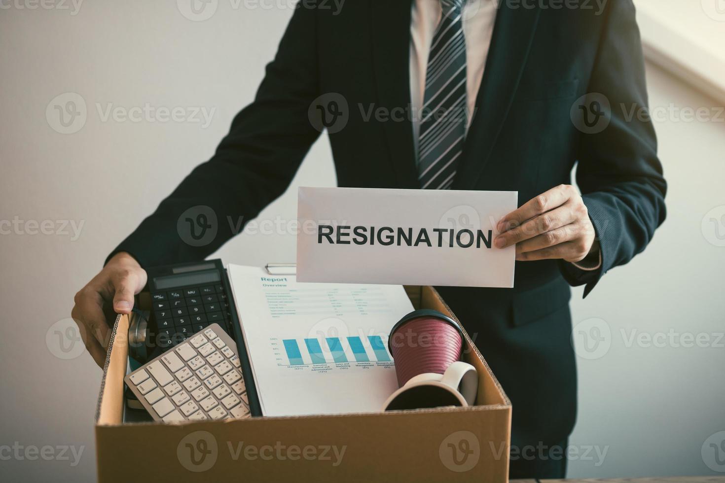 Male employees are keeping their own items on the desk because they are about to go to resign with the manager. photo