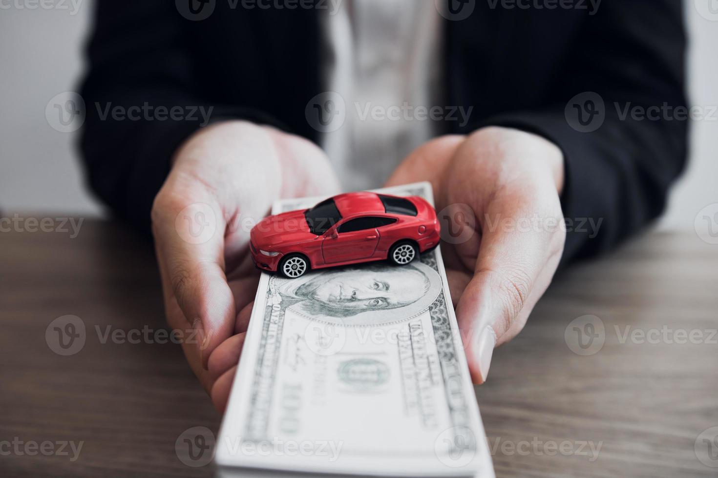 Car salespeople are submitting cash with model cars to customers with concept of buying a new car. photo