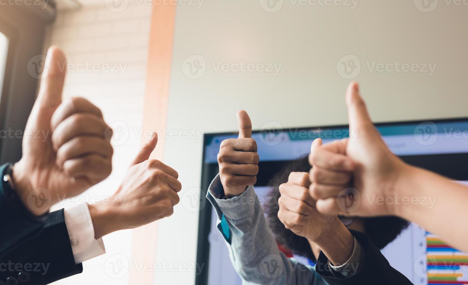Close up business people pulling thumbs up in office room. photo