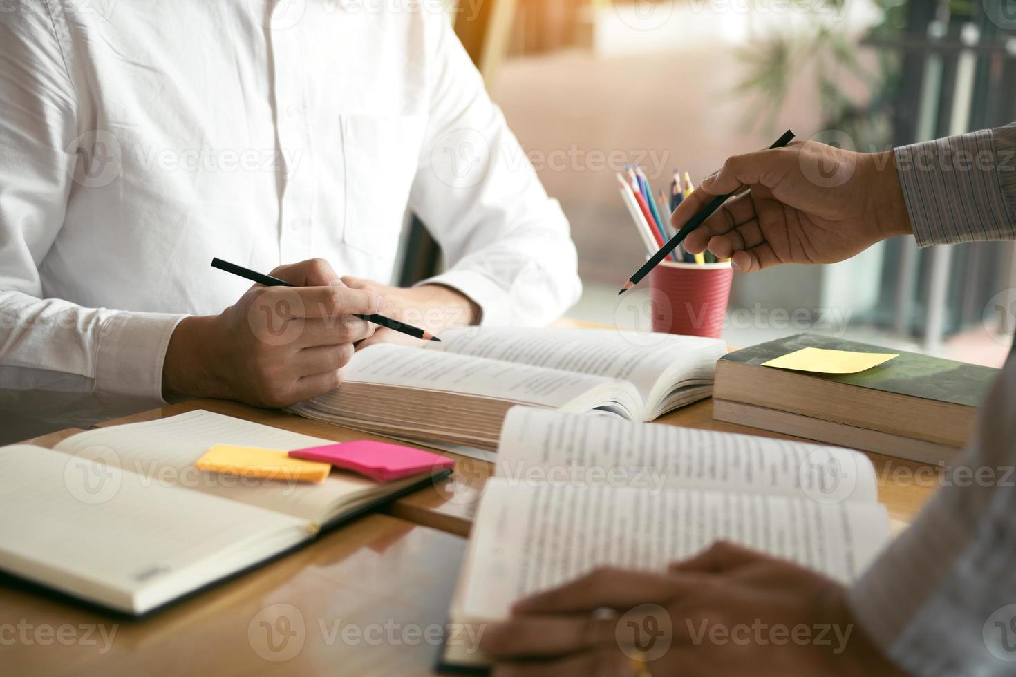 Teenager studying at desk and doing homeworks photo