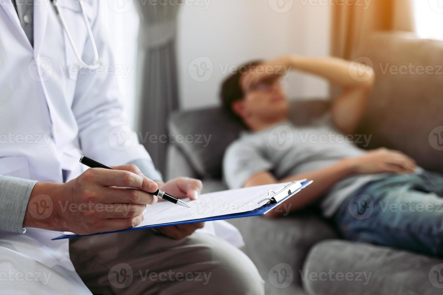 Close up of hand doctor writing the pen and came to visit the patient at home while he headache and had a fever and recorded treatment results. photo