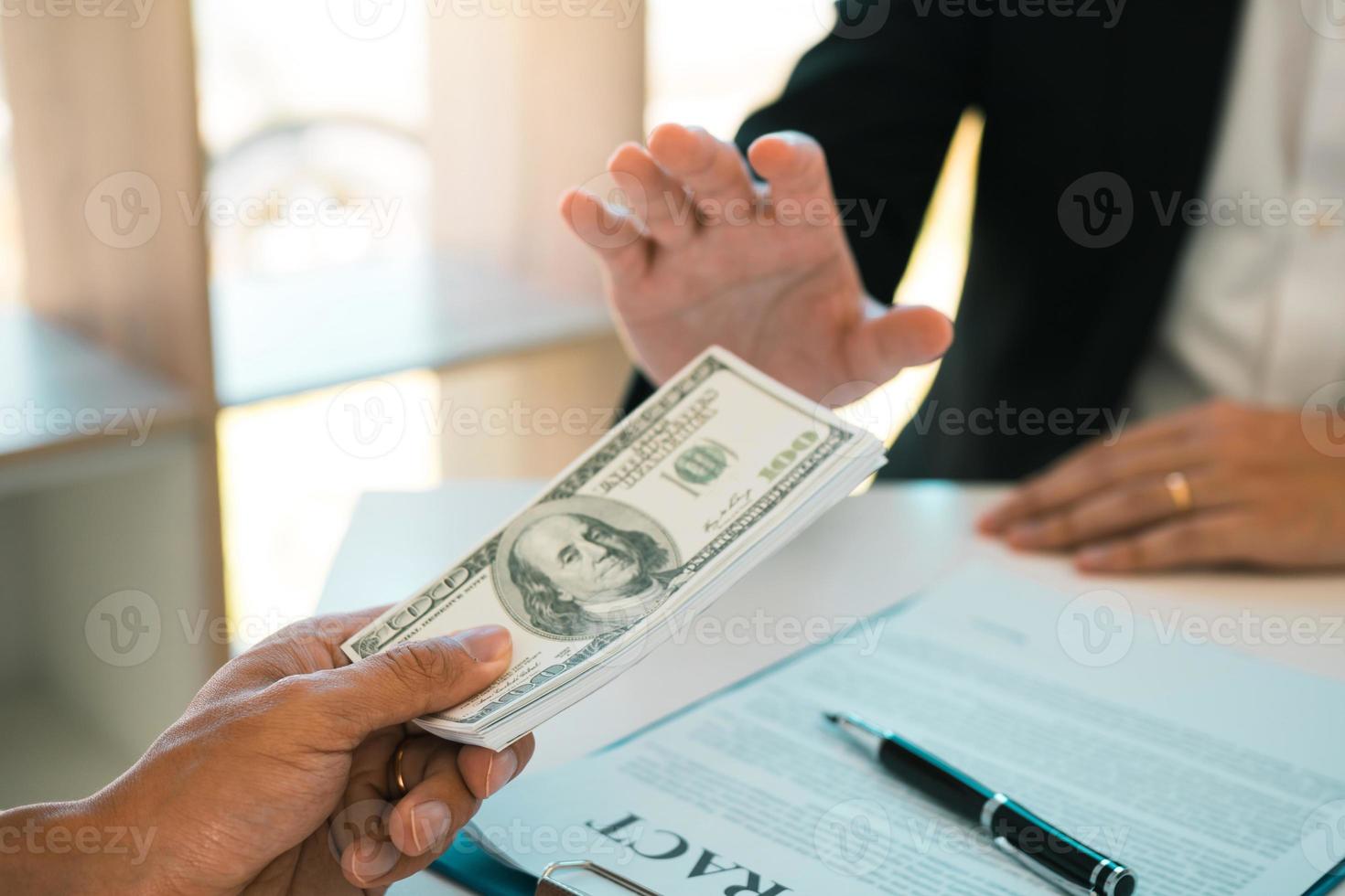 Business person refusing bribe given money by partner with anti bribery corruption concept. photo