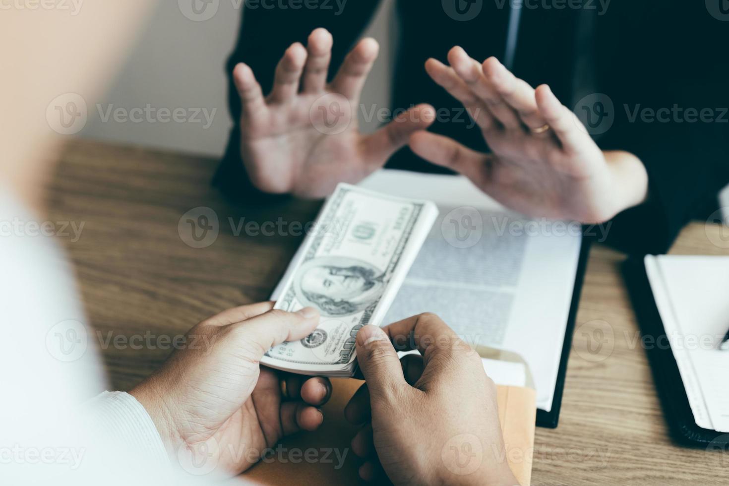 Businessperson refusing bribe given money by partner with anti bribery corruption concept. photo