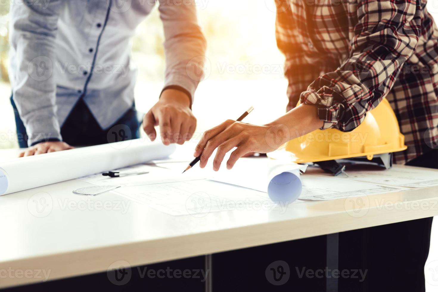 Team architect or engineering people standing working on table together at a construction site. photo