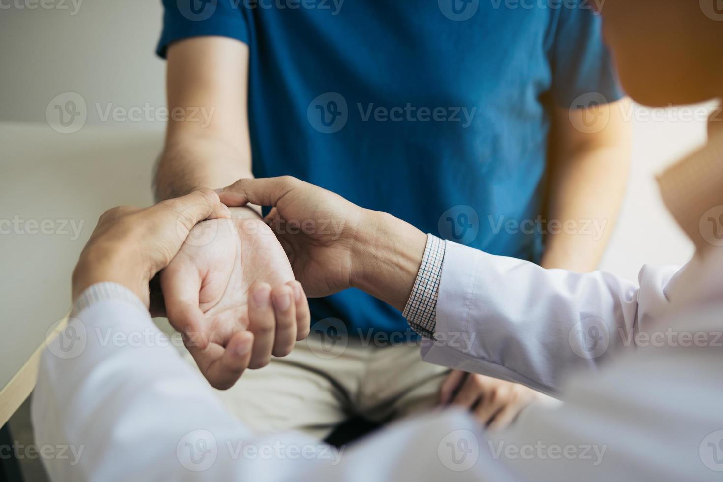 Physical therapist checks the patient wrist by pressing the wrist bone in clinic room. photo