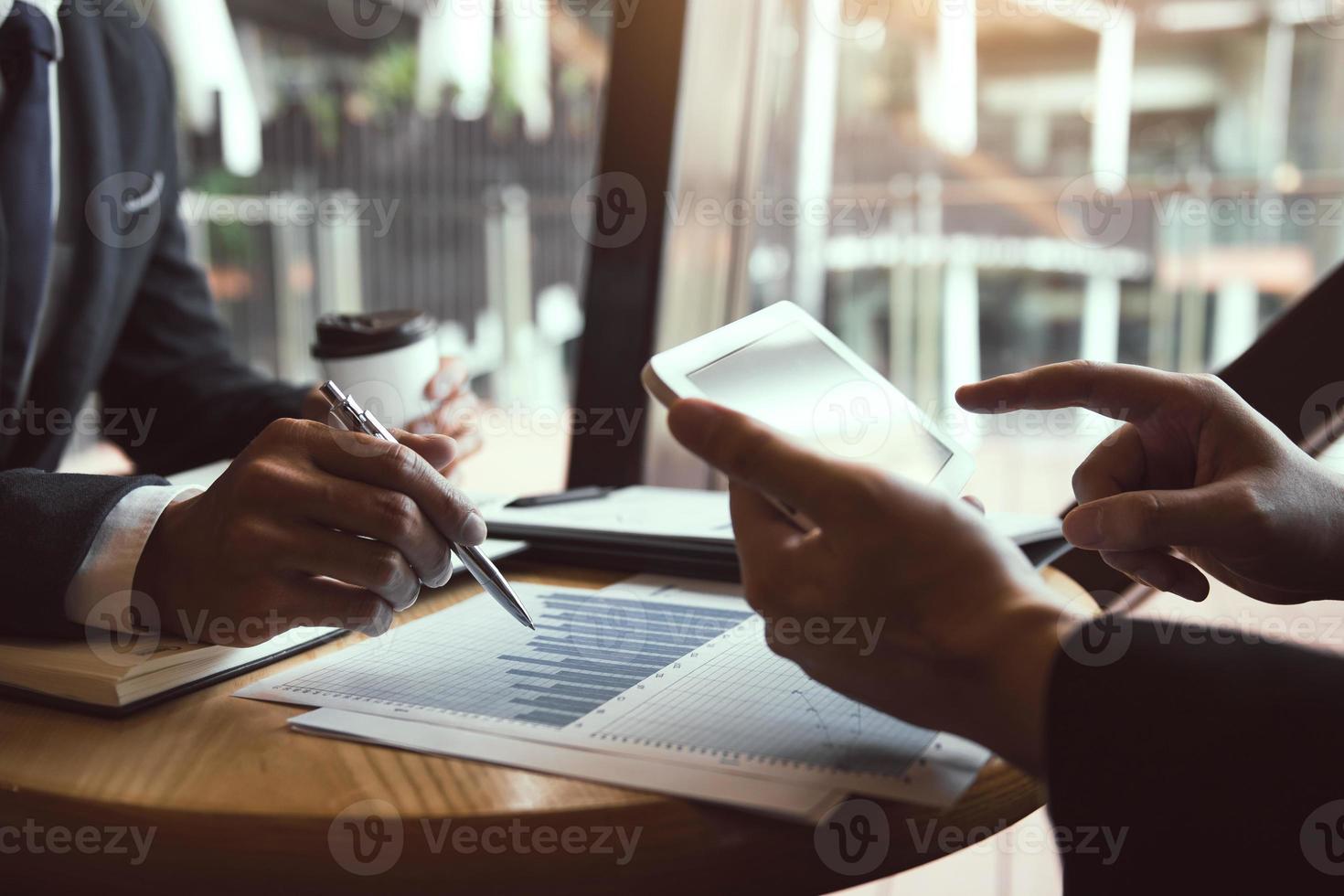 Business partnership coworkers using a tablet to chart company financial statements report and profits work progress and planning in office room. photo