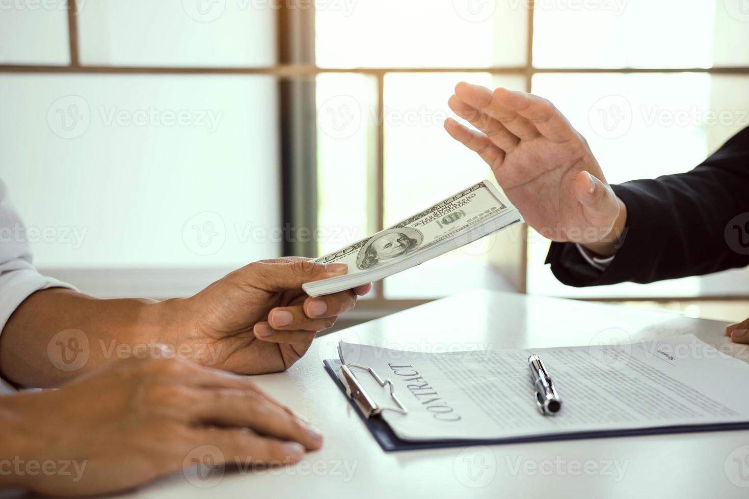 Business person refusing bribe given money by partner with anti bribery corruption concept. photo