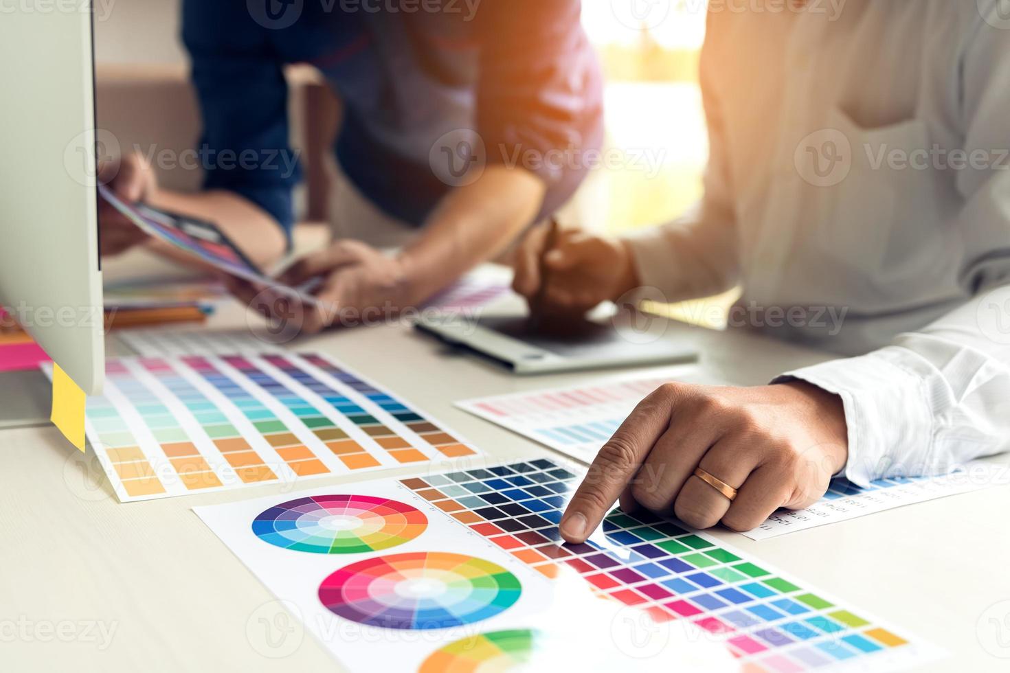 Co-worker graphic designer working with partnership choosing color on desk in modern office. photo